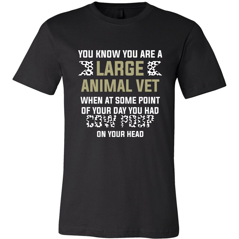 May include: Black t-shirt with a white and black cow print design. The text "You know you are a large animal vet when at some point of your day you had cow poop on your head" is printed on the shirt.