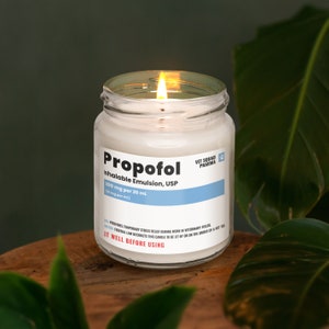a lit candle sitting on top of a wooden table