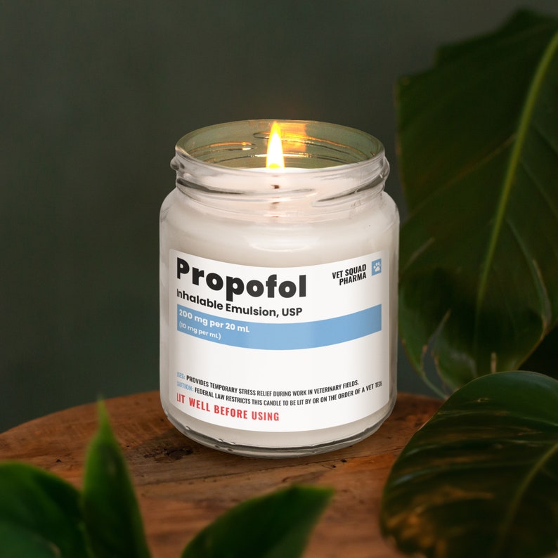 a lit candle sitting on top of a wooden table