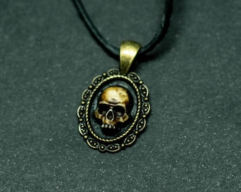 Human skull pendant on bronze base