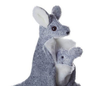 May include: Gray plush kangaroo puppet with a joey in its pouch. The kangaroo is holding the joey with its front paws. The puppet is attached to a wooden stick.