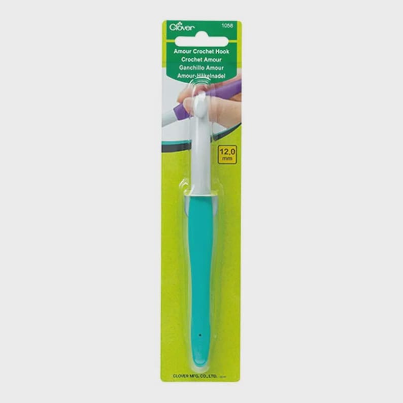 Pode incluir: Uma agulha de croch&ecirc; turquesa e branca com uma etiqueta verde e amarela. A etiqueta diz "Amour Crochet Hook" e "12,0 mm". A agulha &eacute; projetada para uso confort&aacute;vel.