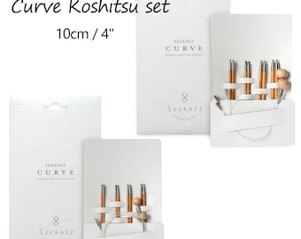 May include: Seeknit Curve Koshitsu set of bamboo knitting needles, 10cm / 4 inches. The set includes multiple needle tips connected by flexible cables, presented on white branded packaging with embossed details and clear product labels.