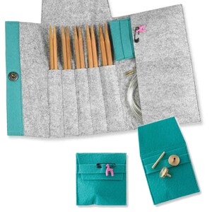 May include: A grey felt roll-up case containing several bamboo knitting needles, a clear plastic cable, and a pink stitch marker. Two additional small teal felt pouches are included, one holding a pink stitch marker and one with brass components.
