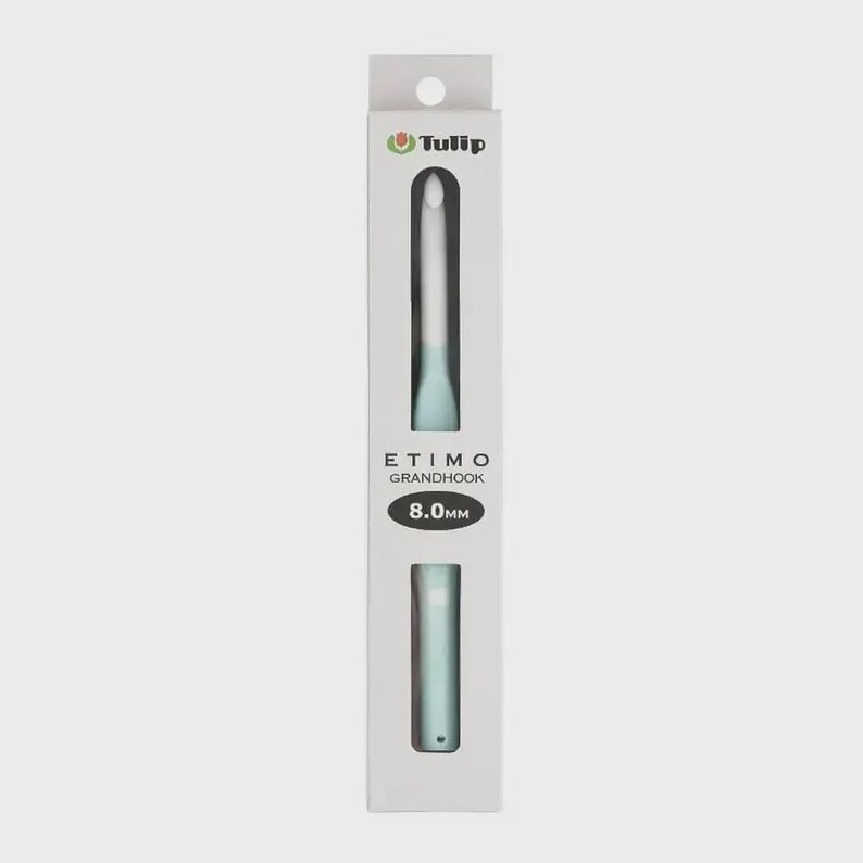 May include: A Tulip Etimo Grandhook crochet hook with a light blue handle and a white hook tip, packaged in a vertical white box. The packaging displays the brand name Tulip, the product name Etimo Grandhook, and the size 8.0mm in black text.