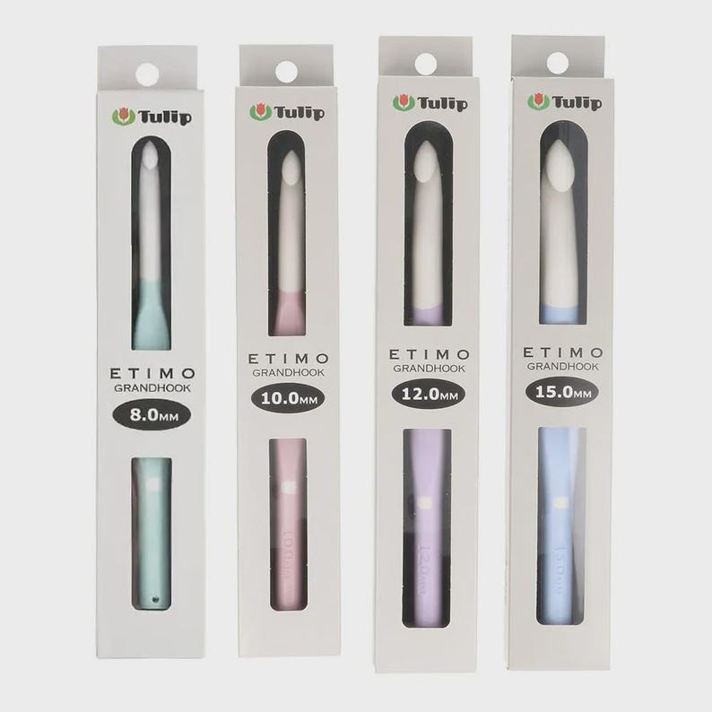 May include: Four Tulip Etimo Grandhook crochet hooks in individual white retail boxes. The hooks are sized 8.0mm, 10.0mm, 12.0mm, and 15.0mm, featuring pastel-colored handles in light blue, pink, lavender, and blue with white hook heads.