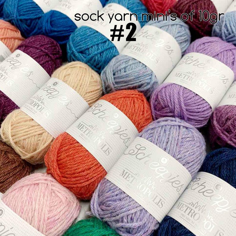 Pu&ograve; includere: Assortimento di gomitoli di filato per calze colorati in varie tonalit&agrave; di blu, viola, rosa, rosso, marrone e beige. Ogni gomitolo &egrave; etichettato "Scheepjes" e "Metropolis" con il testo "sock yarn mini's of 10gr #2".