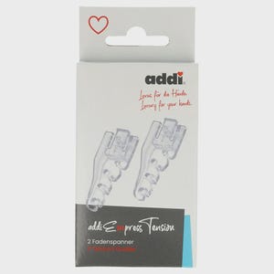 May include: A package of two clear plastic Addi Express Tension guides. The packaging is white with a red heart and the brand name "addi" in black. Text on the package includes "Luxury for your hands" and "2 Tension Guides."