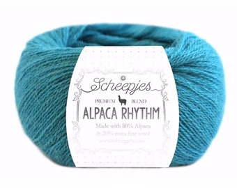 May include: A skein of teal blue yarn labeled "Scheepjes Alpaca Rhythm Premium Blend" with a small alpaca illustration and the text "Made with 80% Alpaca & 20% extra fine wool" and "www.scheepjes.com".