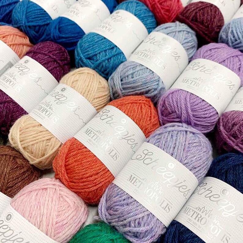 May include: A collection of colorful yarn skeins with the text "Scheepjes" and "with love from Metropolis" on the labels.