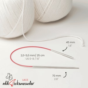 Pode incluir: Um par de agulhas de tricô vermelhas e prateadas com tamanho de 2,0-5,0 mm / 25 cm (US 0-8/10"). As agulhas são mostradas contra um fundo branco com duas bolas de lã branca.