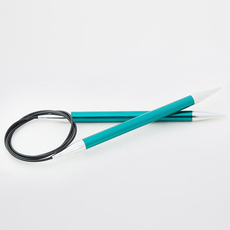 May include: Teal circular knitting needles with silver tips and a black cable. The needles are made of metal and have a smooth, shiny finish. The needles are designed for knitting in the round and are a popular choice for various projects.