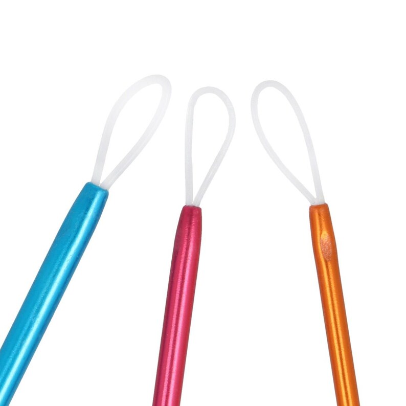 May include: Three crochet hooks with white loops at the top. The hooks are blue, pink, and orange.