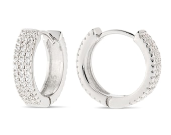 May include: Silver hoop earrings with a row of small cubic zirconia stones around the entire hoop.