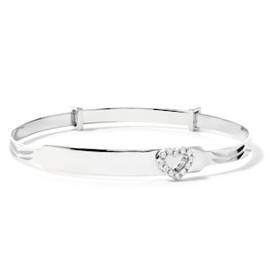 May include: A silver bangle bracelet featuring a heart-shaped charm set with small, clear gemstones. The bracelet has an adjustable clasp and a polished finish. The design is simple and elegant, suitable for gifting. The bracelet is made of silver.