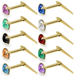 May include: Ten gold nose rings with a variety of coloured gems. The gems are pink, green, black, orange, blue, white, red, emerald green, purple, and light blue.