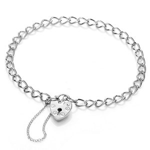 Könnte beinhalten: Ein silbernes Kettenarmband mit einem herzförmigen Vorhängeschloss-Anhänger. Der Anhänger hat ein Schlüsselloch und eine kleine Kette.