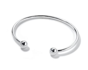 Op de afbeelding: Een zilveren armband met twee ronde ballen aan de uiteinden.