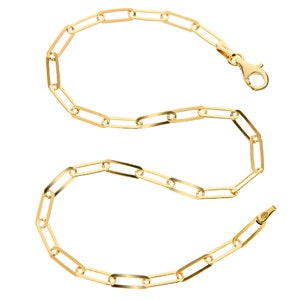 May include: A gold chain necklace with a lobster clasp fastening. The chain is made of oval-shaped links.
