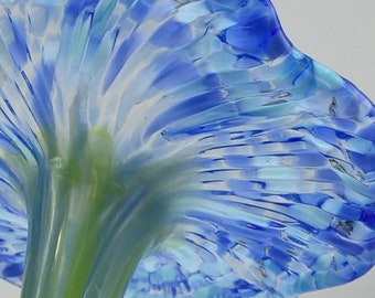 May include: A glass flower sculpture with a blue and white patterned bloom and a green stem.
