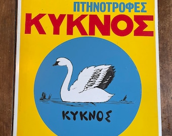 Könnte beinhalten: Vintage Schild mit griechischem Text und einer Schwan-Illustration. Das Schild hat einen gelben Hintergrund mit rotem und blauem Text. Ein weißer Schwan ist in einem blauen Kreis zentriert. Der Text enthält das Wort "KYKNOS".