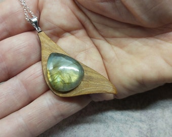 May include: A silver chain necklace with a wooden pendant featuring a teardrop-shaped labradorite gemstone.