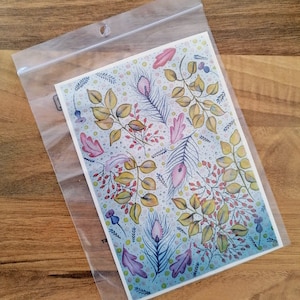 Può includere: Una stampa ad acquerello con uno sfondo blu con un motivo ripetitivo di foglie rosa, gialle e verdi, piume e bacche.