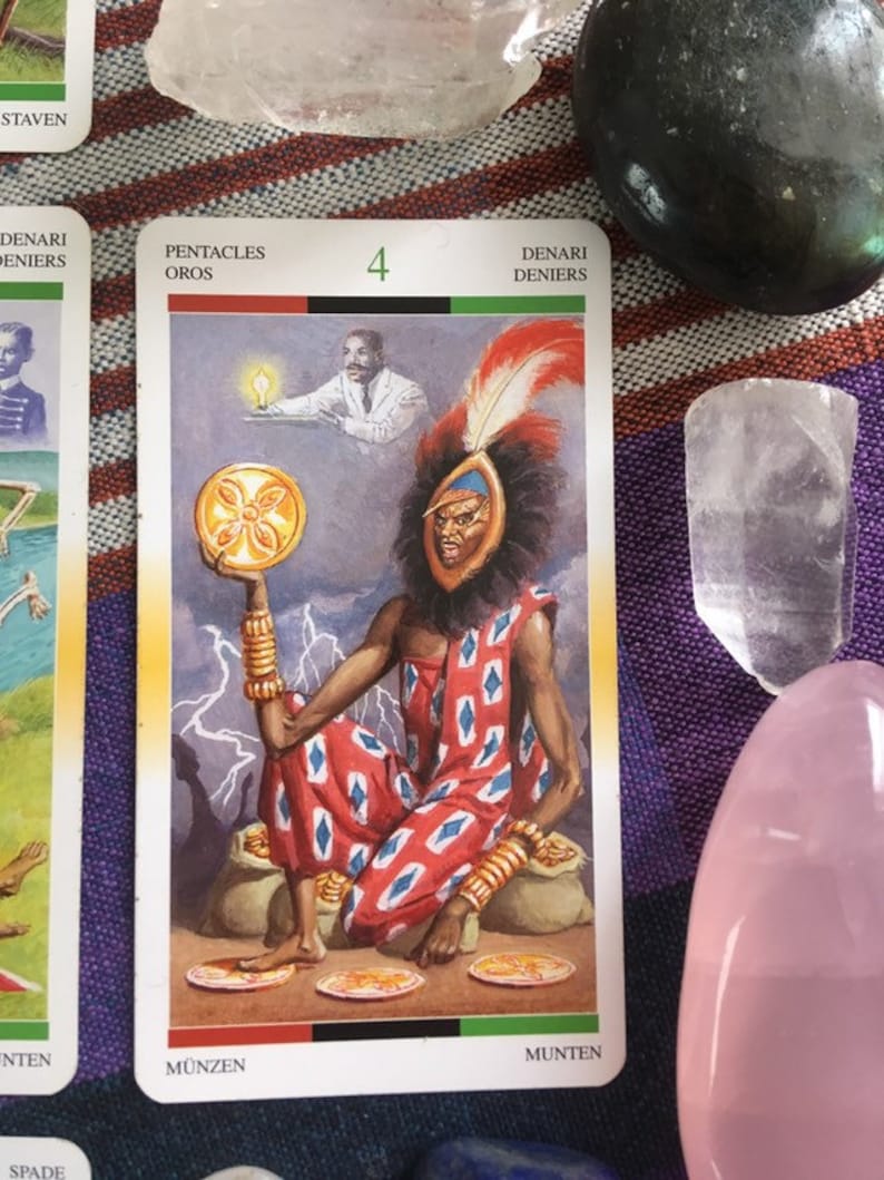 Puede incluir: Carta de tarot que representa el Cuatro de Pent&aacute;culos. La carta presenta una figura sentada que lleva una t&uacute;nica con estampado rojo y blanco y un tocado con plumas. La figura sostiene una moneda de oro con un dise&ntilde;o de flor. La carta tambi&eacute;n presenta una figura blanca en el fondo que sostiene una l&aacute;mpara encendida.