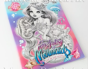 Peut inclure: Une couverture de livre de coloriage représentant une sirène aux longs cheveux flottants, une coquille et un hippocampe. Le titre du livre est "My Fantasy of Mermaids" avec les mots "dark & light versions" en dessous. La couverture est un dégradé de rose, violet et bleu.