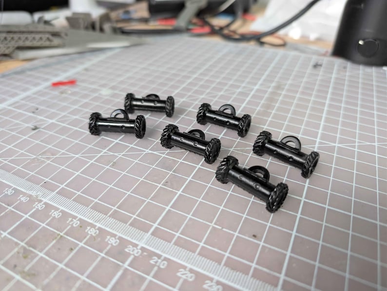 May include: A white ceramic mug with a black handle and the text "But First, Coffee" in a black, handwritten-style font. The mug is on a white surface.