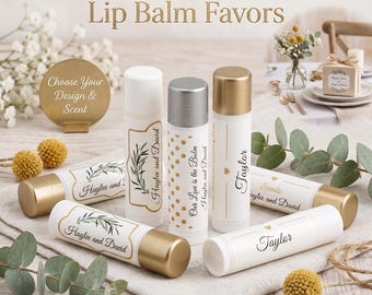 May include: White lip balm tubes with gold or silver caps are arranged on a neutral surface. The tubes are labeled with names and phrases like "Haylee and David" and "Our Love is the Balm." The text "Personalized Wedding Lip Balm Favors" is at the top.