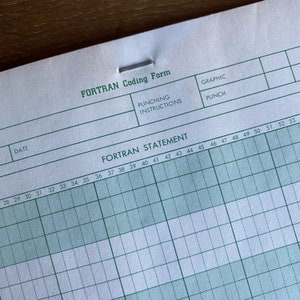 May include: A blank FORTRAN coding form with green lines and columns numbered 28 to 53. The form has headings for "FORTRAN STATEMENT", "PUNCHING INSTRUCTIONS", "GRAPHIC", and "PUNCH".