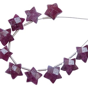 May include: A strand of pink star-shaped gemstone beads strung on a silver wire. The beads are faceted and have a shiny finish.
