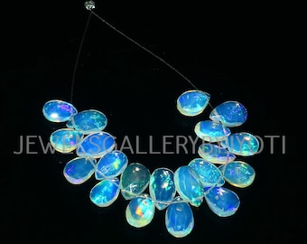 May include: A strand of iridescent blue and white teardrop-shaped opal beads on a silver chain. The beads are strung together in a loose, flowing pattern.