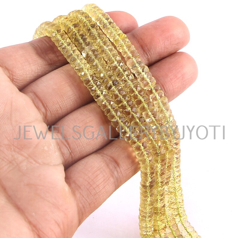 May include: Multiple strands of faceted, yellow gemstone beads. The small, square-shaped beads are strung together. The image includes the text "JEWELS GALLERY JYOTI".