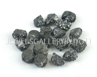 May include: A collection of black diamonds, also known as carbonado diamonds, in various sizes and shapes. These rough diamonds are a rare and valuable type of diamond.