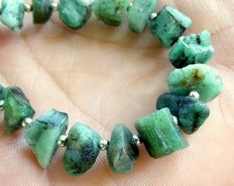 Op de afbeelding: Een groene smaragdstenen armband met zilveren kralen. De smaragdstenen zijn ruw en onregelmatig van vorm.