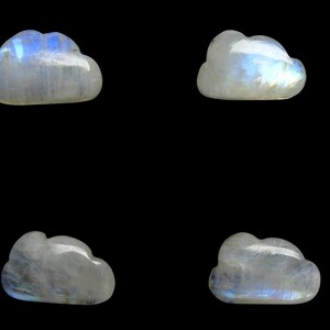Peut inclure: Quatre sculptures en forme de nuage en pierre de lune blanche irisée sur un fond noir.