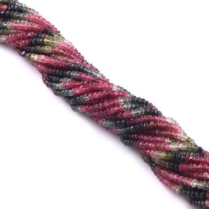 May include: A strand of multi-colored gemstone beads. The beads are a mix of pink, green, and black. The beads are small and round.