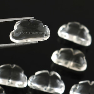 May include: A group of clear quartz crystal cloud shaped beads. The beads are smooth and polished. The beads are approximately 1 inch in size.