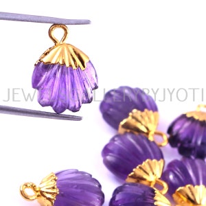 May include: Purple amethyst gemstone shell shaped charms with gold accents. Each charm has a loop for attaching to jewelry.