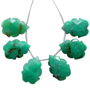 May include: A strand of six green gemstone beads, each carved in a unique leaf shape. The beads are strung on a silver wire.