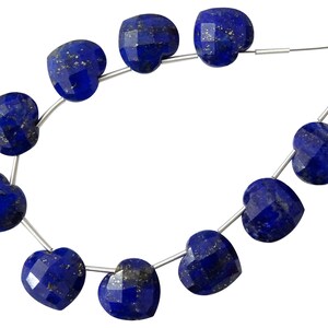May include: A strand of dark blue heart-shaped lapis lazuli beads with gold flecks. The beads are strung on a silver wire.