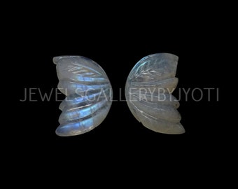 May include: Two carved moonstone butterfly wings, each with a delicate leaf design. The wings are translucent and have a light blue iridescent sheen.