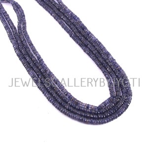 May include: A strand of blue gemstone beads, likely amethyst or sapphire, strung together in a long necklace. The beads are faceted and have a slightly irregular shape, giving the necklace a rustic and natural look.