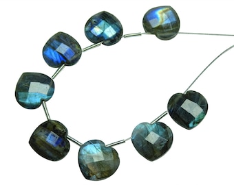 May include: A strand of heart-shaped labradorite beads, each bead is a deep blue with iridescent flashes of green and gold. The beads are strung on a silver wire.