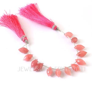 May include: A strand of faceted, petal-shaped pink gemstones with bright pink tassel accents. The gemstones are strung on a silver wire, and the tassels are attached with silver wire. The gemstones are a light coral color.