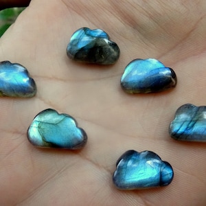 Op de afbeelding: Zes regenboogkleurige blauwe en groene labradorit-cabochons, gesneden in de vorm van wolken.