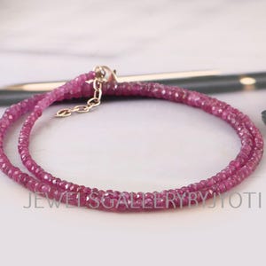 以下が含まれることがあります： ピンクの宝石ビーズでできた2連ネックレス。ネックレスは小さなファセットカットのビーズで作られており、シルバーの留め具が付いています。