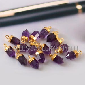Peut inclure: Un groupe de 12 pendentifs en améthyste avec des embouts plaqués or. Les pierres d'améthyste sont facettées et ont une forme pointue. Les pendentifs sont parfaits pour la fabrication de bijoux.